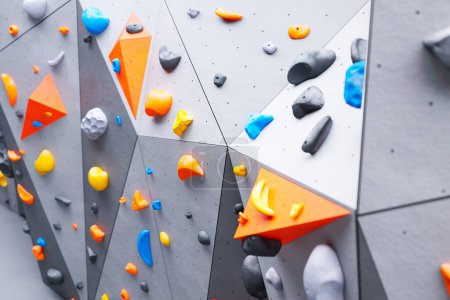 Photo for A picture of the climbing or bouldering wall. Rock extreme sport activity for indoor training and exercise in leisure time. Test your skills as you navigate through a variety of routes and obstacles. - Royalty Free Image