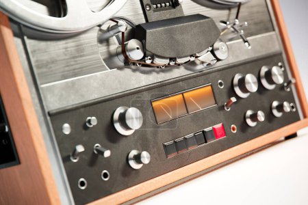 Téléchargez les photos : Gros plan sur les boutons d'un magnétophone analogique professionnel vintage bobine à bobine audio. Les rouleaux sont en mouvement, l'enregistrement ou la musique est en cours de lecture. Machine à enregistrer rétro parfaite pour audiophile ou amateur. - en image libre de droit