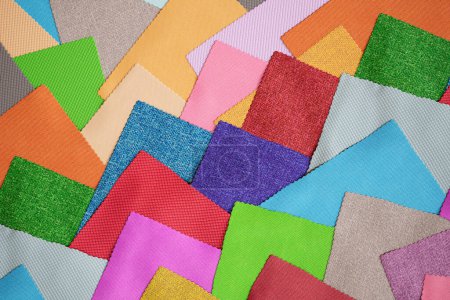 Un ensemble d'échantillons de tissu coloré. Pièces carrées en différentes couleurs. Concept de tendances de décoration textile pour meubles ou intérieurs. Passionné de bricolage. Designer textile. Collecte de tissus.