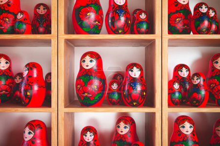 Una cautivadora colección muestra muñecas de anidación Matrioska ornamentalmente pintadas a mano, un símbolo de la herencia rusa, dispuestas meticulosamente en estanterías de madera para su exhibición..