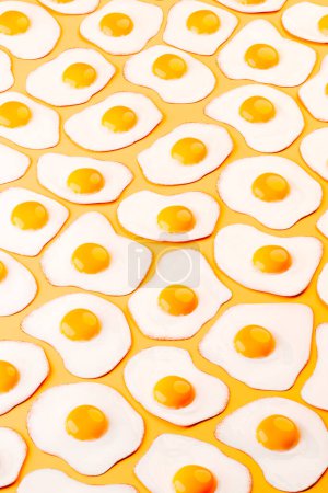 Cette image capture une série d'?ufs parfaitement frits et ensoleillés disposés dans un motif sans couture, sur un fond orange frappant, mettant l'accent sur le contraste des couleurs et l'attrait culinaire.