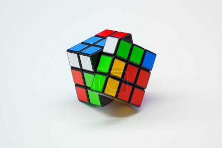 Foto de Esta imagen muestra un Cubo de Rubik intrincadamente resuelto posicionado sobre un fondo blanco, enfatizando los cuadrados de colores brillantes y el diseño icónico del cubo.. - Imagen libre de derechos