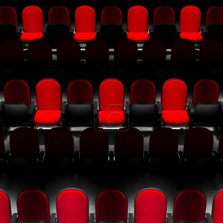 Ein weiträumiger Blick auf leuchtend rote Samt-Theatersitze vor einem krassen schwarzen Hintergrund bietet eine eindrucksvolle Bildkomposition, die an die Vorfreude vor einer Vorstellung erinnert.