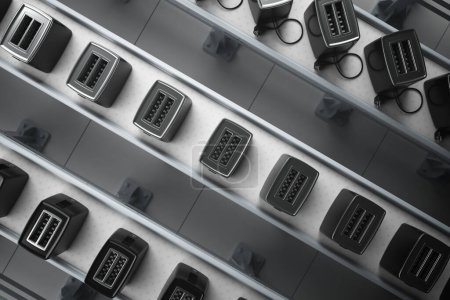 Les grille-pain noirs de précision aux finitions argentées élégantes sont disposés symétriquement sur une série de courroies transporteuses, mettant en valeur l'excellence de la fabrication moderne dans une installation industrielle..