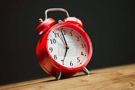 Foto de Un clásico reloj despertador vintage rojo muestra 10: 10 en su cara, posicionado prominentemente en un escritorio de madera oscura, encarnando la esencia del diseño atemporal y la puntualidad. - Imagen libre de derechos