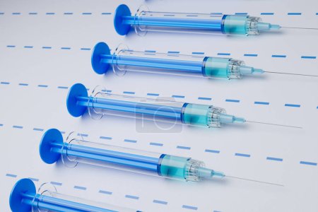 Foto de Vista de cerca de múltiples jeringas azules desechables organizadas en filas, simbolizando el profesionalismo médico en vacunas y tratamientos. - Imagen libre de derechos