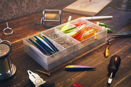 Close-up view showcasing a varied selection of fishing tackle, including colorful lures, sharp hooks, and essential tools, arrayed on an aged wooden surface for an outdoor angling adventure.