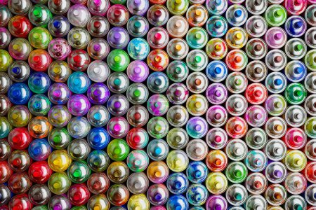 Photo for Overhead shot capturing a vivid collection of spray paint cans with assorted colored caps, representing an artistic burst of graffiti supplies on a flat backdrop. - Royalty Free Image