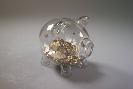 Une tirelire transparente regorgeant de pièces d'or, illustrant la croissance financière, les stratégies d'investissement et l'importance de l "épargne dans un contexte de gradient frappant.