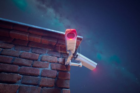Photo for High-tech security camera affixed to an old brick wall, keenly observes under a celestial night sky, offering a blend of antiquity and modern surveillance. - Royalty Free Image