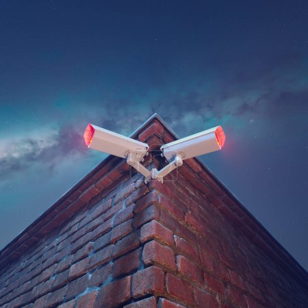 Illuminated by dusk, dual CCTV security cameras vigilantly stand guard on a red brick wall, epitomizing modern urban surveillance and public safety measures.