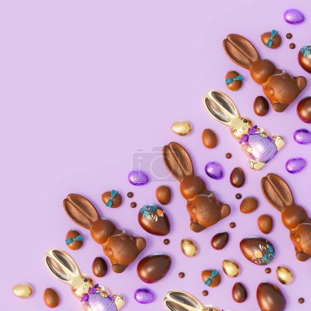 Foto de Un encantador arreglo de conejos de Pascua de chocolate rodeado de una vibrante variedad de huevos de colores colocados sobre un llamativo fondo púrpura captura la esencia de las celebraciones de Pascua. - Imagen libre de derechos