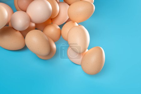 Téléchargez les photos : Un arrangement d'œufs bruns frais présentés sur une surface bleue frappante, incarnant des thèmes de l'agriculture biologique, une alimentation saine et des ingrédients culinaires. - en image libre de droit
