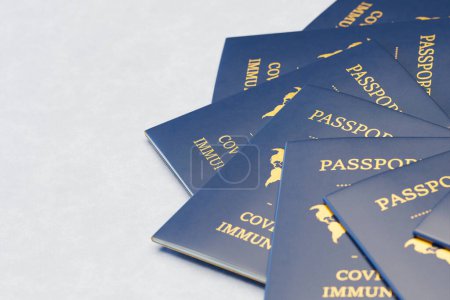 Foto de Una colección de pasaportes internacionales de la vacuna COVID-19 repartidos en una superficie neutral que simboliza la nueva normalidad para las regulaciones mundiales de viajes y salud. - Imagen libre de derechos
