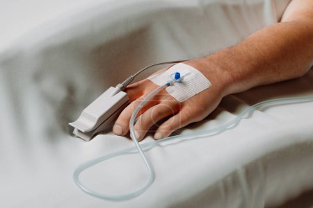 Detailed view of a patient's hand with a secured IV line for medication administration, showcasing essential healthcare practices within a clinical environment.