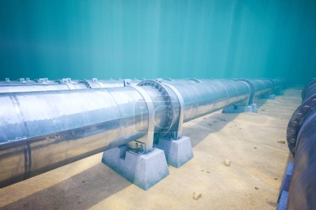 Ein neu installierter Pipelineabschnitt, der auf Betonstützen ruht, erstreckt sich über den sandigen Meeresboden und spiegelt die Fortschritte in der Meerestechnik wider..