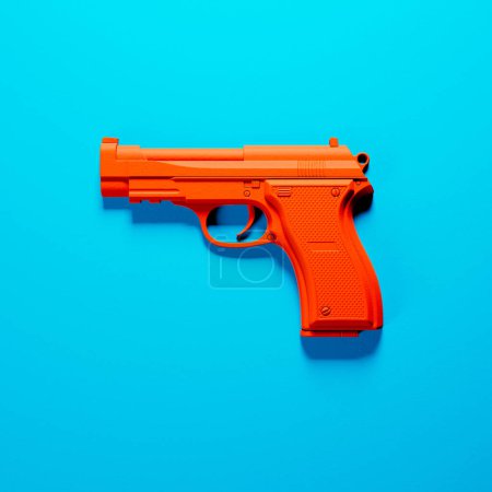 Als Spielzeugattrappe sticht diese auffällige orangefarbene Spielzeugpistole vor tiefblauem Hintergrund hervor und betont in ihrem schlichten Design Lebendigkeit und kindliche Fantasie..