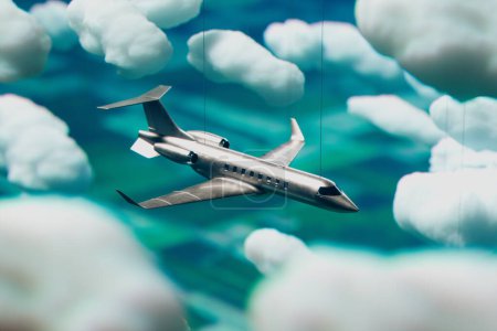 An exquisitely detailed model of a private jet appears to soar in flight, artfully suspended against a backdrop of fluffy clouds in a clear blue sky, evoking a sense of luxury travel.