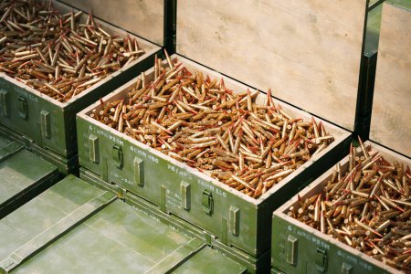 Vue d'ensemble de nombreuses caisses de munitions militaires vertes débordant de calibres variés, solidement assemblées pour une distribution et une protection efficaces.