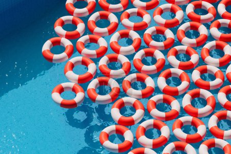 Aerial shot captures a striking grid of red and white lifebuoys arranged in a clear blue swimming pool, symbolizing systematic aquatic safety and rescue operations.