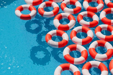 An orderly pattern of red and white lifebuoys provides a stark contrast against the shimmering blue waters of a serene swimming pool, symbolizing emergency preparedness.