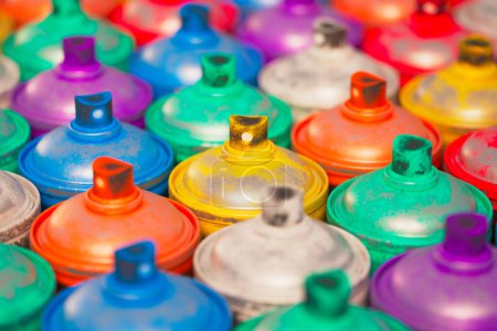 Foto de Este primer plano muestra una colorida variedad de latas de pintura en aerosol con boquillas y tapas detalladas, que evocan una sensación de diversidad y potencial artístico en un vibrante telón de fondo. - Imagen libre de derechos