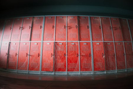 Téléchargez les photos : Une vue en perspective tendue présentant une séquence de casiers scolaires rouges animés avec des rayures notables et des grilles de ventilation, emblématiques de la vie étudiante et de la vie privée. - en image libre de droit