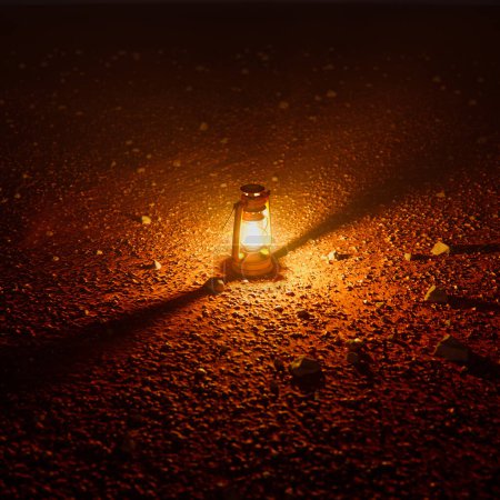Téléchargez les photos : Une lanterne illuminée brille sur un chemin de gravier isolé sous le ciel nocturne, offrant une balise de chaleur et de sécurité dans l'obscurité tranquille, créant une scène pittoresque. - en image libre de droit