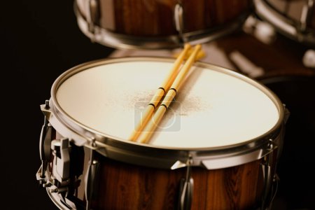 Photo for A finely-detailed image displaying a snare drum's surface with two crossed drumsticks on top, perfectly capturing the essence of percussive music. - Royalty Free Image