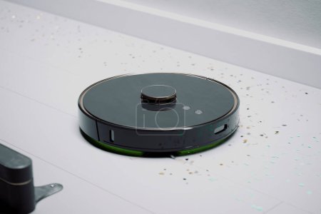 Ein autonomer Staubsaugerroboter räumt effizient mit buntem Konfetti auf, das auf einem makellosen weißen Fliesenboden verstreut ist und die Smart-Home-Technologie bei der Arbeit hervorhebt.