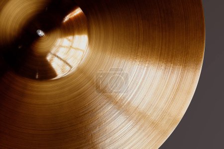 Téléchargez les photos : Ce rendu détaillé capture la surface texturée complexe d'une cymbale en laiton, avec une lumière réfléchissante créant des contrastes frappants et soulignant son exécution. - en image libre de droit