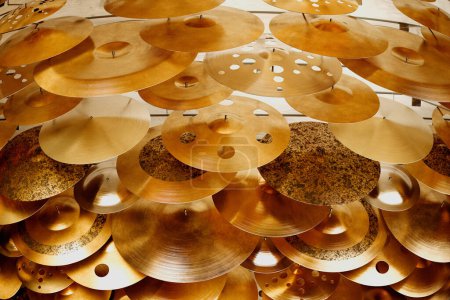 Close-up of an array of cymbals, highlighting the intricate textures, finishes, and craftsmanship in a tightly stacked composition for musical diversity.