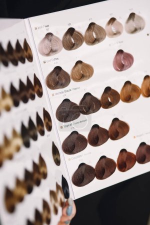 Hair color samples on palette swatch book. Close up photo of hair stylist with hair samples of different colors