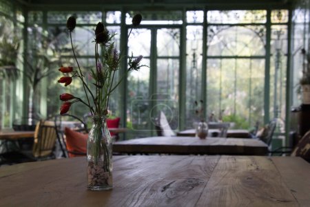 Foto de Un jarrón de flores sobre una mesa de madera en un cenador de hierro forjado. Foto de alta calidad - Imagen libre de derechos