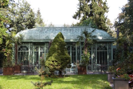 Foto de Jardín de invierno de hierro forjado en un hermoso jardín. Un gazebo vintage. Foto de alta calidad - Imagen libre de derechos