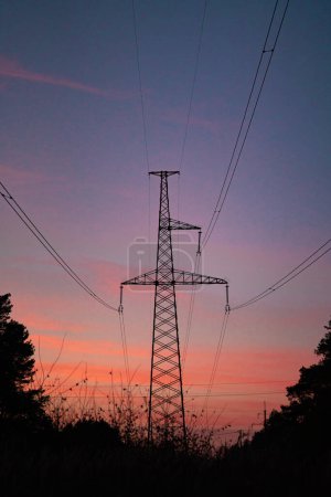 Foto de Líneas de alta tensión .silhouette de la torre en la noche contra el fondo del cielo de color - Imagen libre de derechos