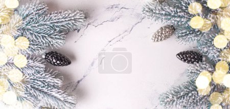 Téléchargez les photos : Cadre de branches sapin, cônes en verre argenté et lumières bokeh sur fond d merveille blanche. Simple composition de Noël. Vue de dessus. Place pour le texte. - en image libre de droit