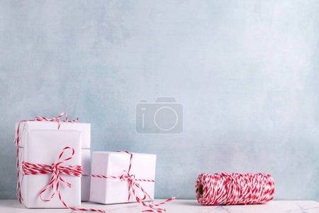 Photo for Postcard with  wrapped presents and bikers twine against  blue textured  wall.  Place for text. - Royalty Free Image