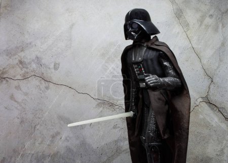 Téléchargez les photos : Bologne - Italie - Décembre 1, 2022 : Dark Vador réplique costume avec sabre léger. Dark Vador est un personnage de la saga Star Wars. - en image libre de droit