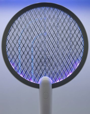 Photo for Electric Fly and Mosquito Swatter on charging base switched on. - Royalty Free Image