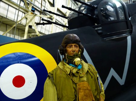 Photo for Hendon, London - England, UK - June 29, 2014: Royal Air Force (RAF) Museum. Real historic aircrafts from all over the world. In foreground a pilot close to a British Defiant. - Royalty Free Image