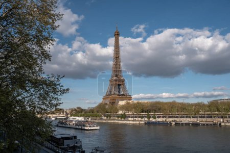 Foto de Torre Eiffel con una barcaza que pasa en un día soleado en París - Imagen libre de derechos