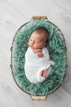 Téléchargez les photos : Le nouveau-né en couche blanche dort dans le panier - en image libre de droit