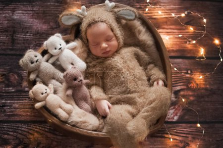 Téléchargez les photos : Nouveau-né 10 jours en costume de cerf tricoté et jouets ours pour Noël. - en image libre de droit