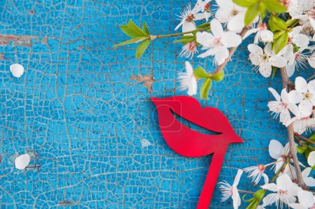 Téléchargez les photos : Red miniature female lips on wooden background with flowering branch. - en image libre de droit