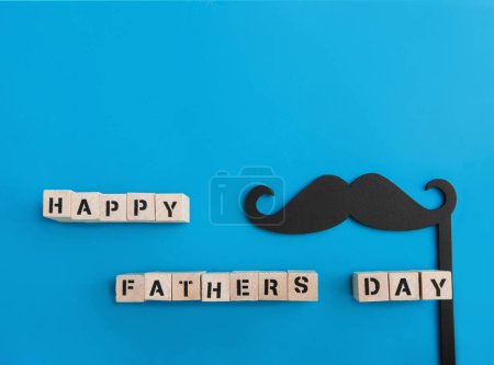 Téléchargez les photos : Inscription Happy Fathers Day and black mustache decor on blue background. - en image libre de droit