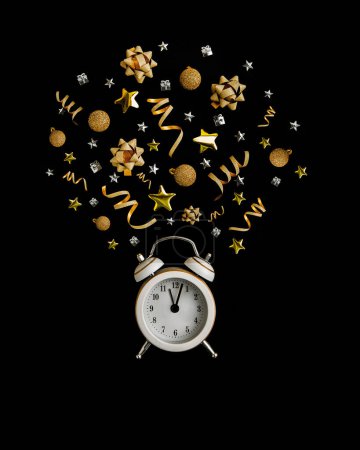 Foto de Concepto de venta de Año Nuevo. Reloj despertador, oropel, bolas de Navidad, regalos sobre fondo negro. - Imagen libre de derechos