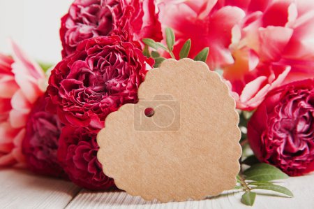 Téléchargez les photos : Carte de vœux avec étiquette et roses rouges en gros plan. Journée internationale de la femme, Fête des Mères, 8 mars concept. - en image libre de droit