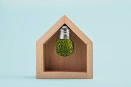Photo for Light bulb inside house on blue background. Power energy, business idea, ecology, loan, mortgage, property or home concept. Eco friendly house, Environmental protection. - Royalty Free Image