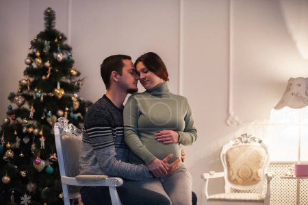 Téléchargez les photos : Couple aimant en prévision du bébé. L'homme embrasse le ventre de la femme enceinte. - en image libre de droit